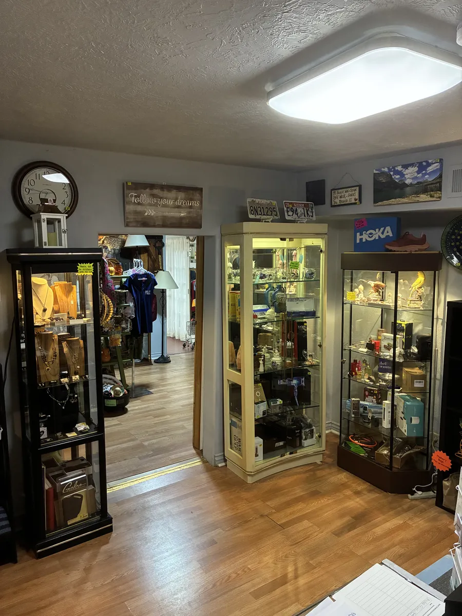 Glass display cabinets, a mirror and shelves of decorative pieces inside BAM Thrift store