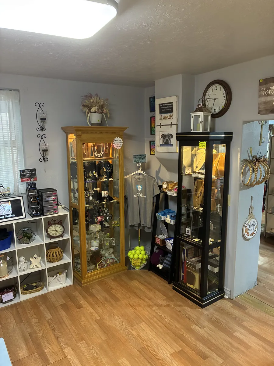 Jewelry, clocks and small decorative items arranged around display cabinets at BAM Thrift store